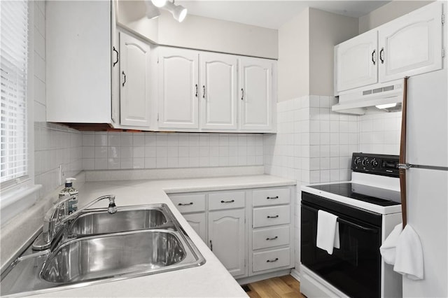 kitchen featuring white cabinets, white appliances, sink, and light hardwood / wood-style floors