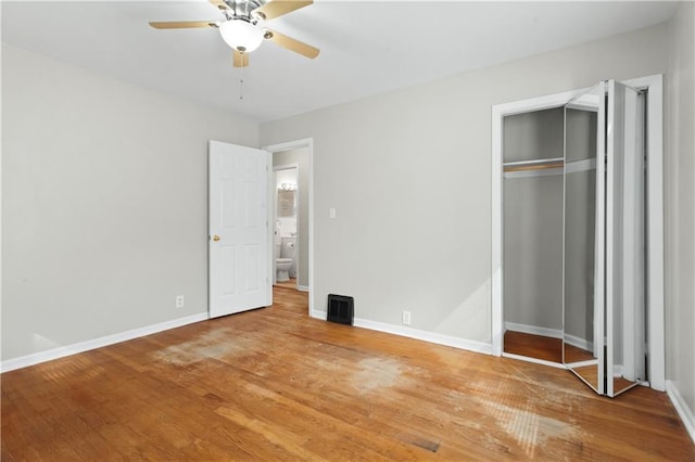 unfurnished bedroom with a closet, hardwood / wood-style floors, and ceiling fan