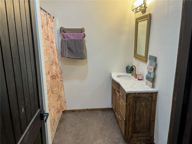 full bath with curtained shower, baseboards, and vanity