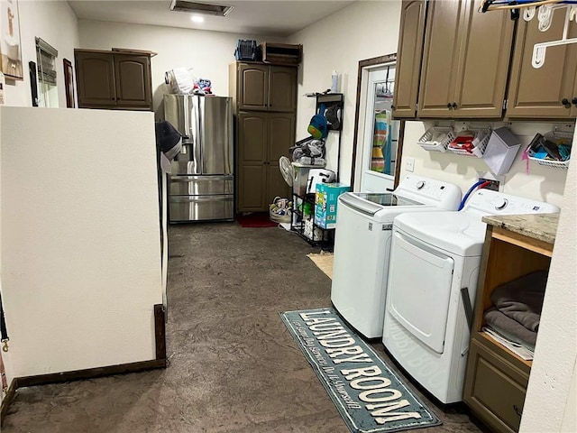 clothes washing area featuring cabinet space and washing machine and clothes dryer