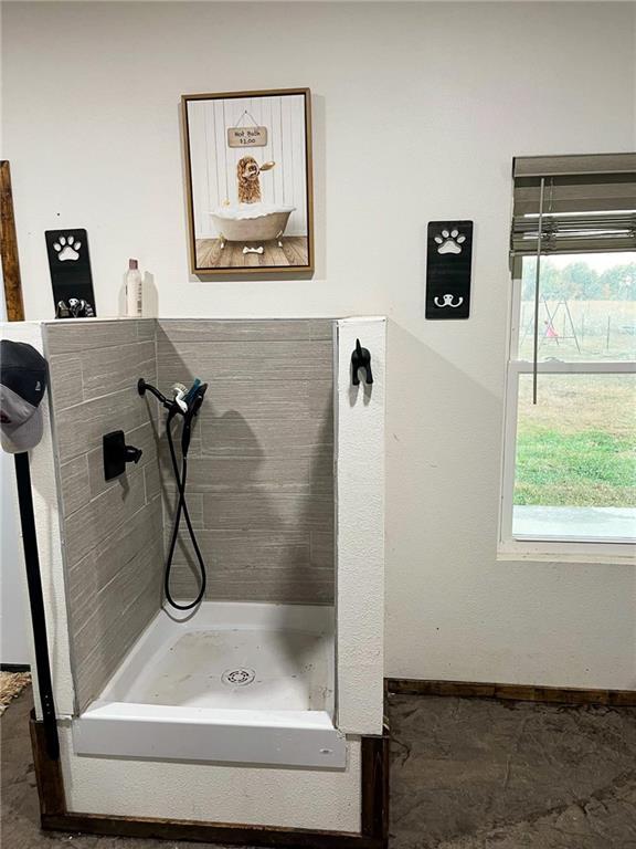 bathroom with a stall shower and baseboards