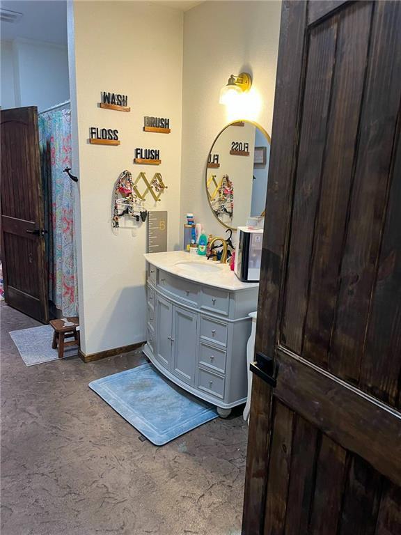 full bathroom featuring curtained shower, vanity, and baseboards