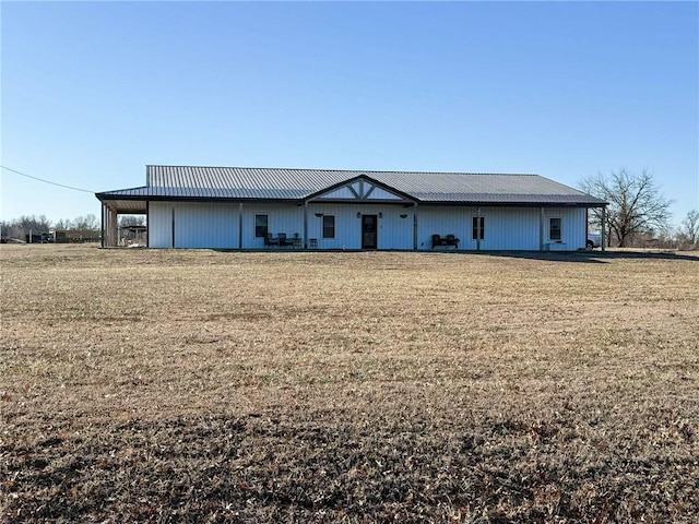 view of front of home with metal roof and a front lawn