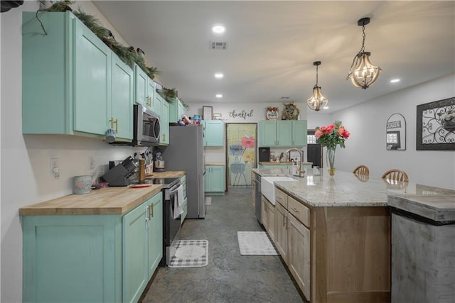 5528 Lostine Rd, Galena, KS 66739 - kitchen featuring a sink, visible vents, stainless steel appliances, decorative light fixtures, and a spacious island