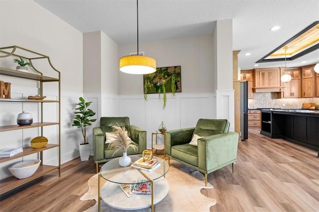 sitting room with a skylight and light wood-type flooring