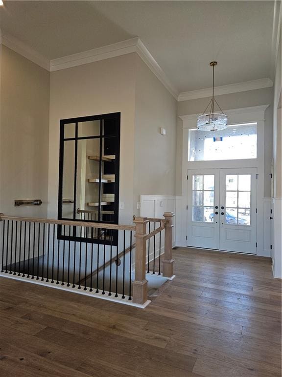 entryway with ornamental molding, hardwood / wood-style floors, and french doors