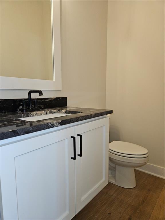 bathroom featuring hardwood / wood-style flooring, vanity, and toilet