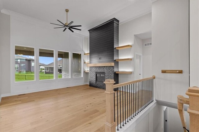 4287 Lake Shore Ct, Basehor, KS 66007 - living room featuring visible vents, crown molding, wood finished floors, a fireplace, and a ceiling fan