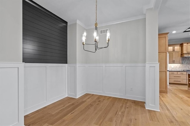 4287 Lake Shore Ct, Basehor, KS 66007 - unfurnished dining area featuring visible vents, crown molding, a decorative wall, and a chandelier