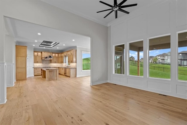 4287 Lake Shore Ct, Basehor, KS 66007 - unfurnished living room featuring light wood-style floors, ornamental molding, a ceiling fan, and a decorative wall