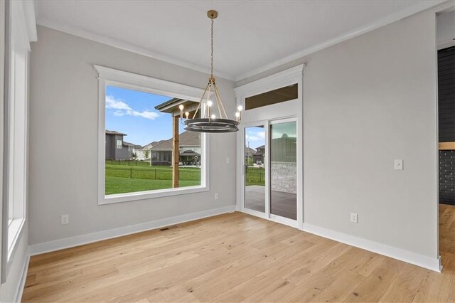 4287 Lake Shore Ct, Basehor, KS 66007 - unfurnished dining area with baseboards, plenty of natural light, wood finished floors, and a chandelier