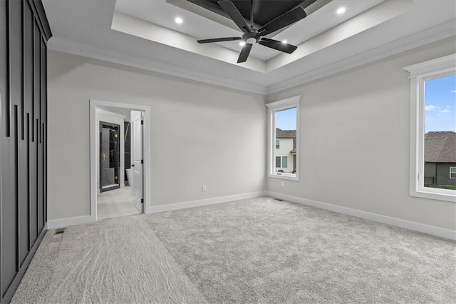 4287 Lake Shore Ct, Basehor, KS 66007 - unfurnished bedroom featuring a tray ceiling, light carpet, and baseboards