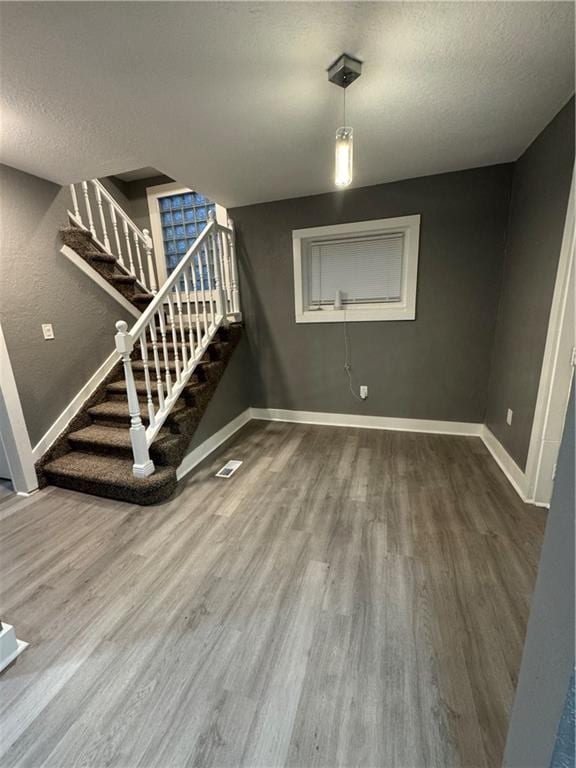 interior space with a textured ceiling and hardwood / wood-style flooring