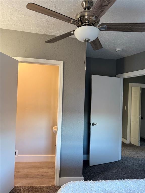 unfurnished bedroom featuring ceiling fan, wood-type flooring, and a textured ceiling