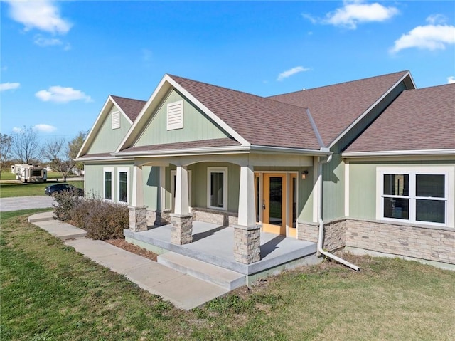 back of property featuring a lawn and covered porch