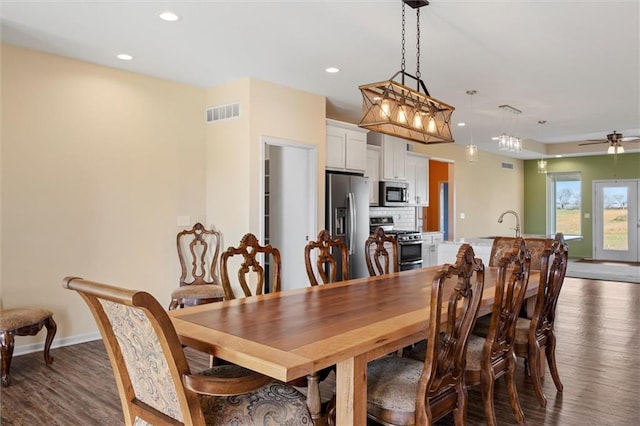 dining space featuring ceiling fan and dark wood-type flooring