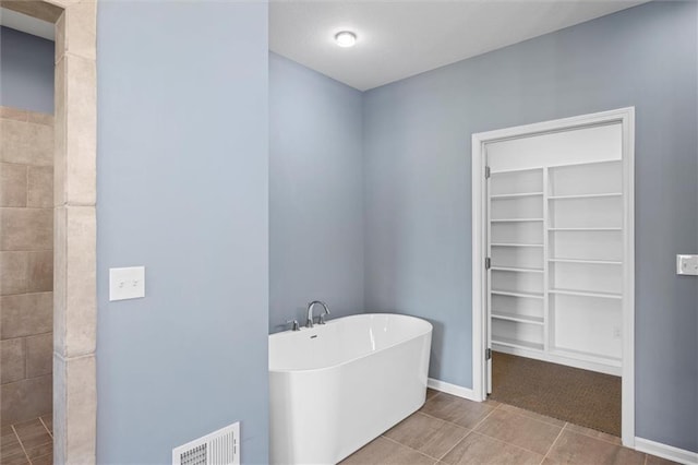 bathroom with separate shower and tub and tile patterned flooring