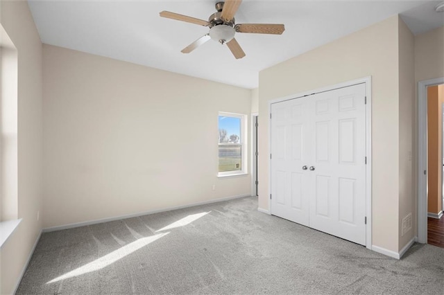 unfurnished bedroom with ceiling fan, light colored carpet, and a closet