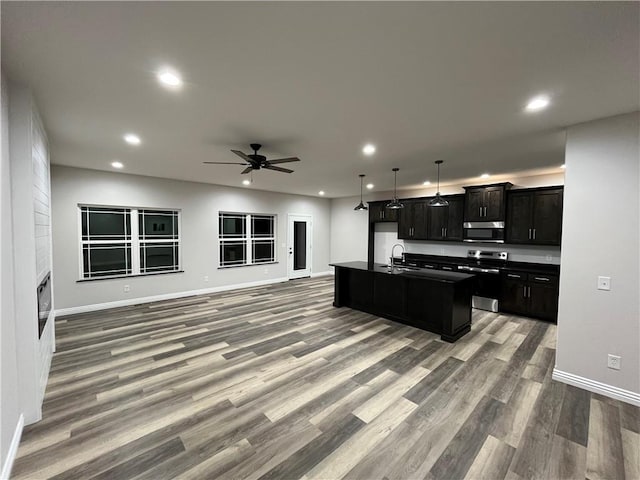 kitchen featuring stainless steel appliances, hardwood / wood-style flooring, sink, an island with sink, and ceiling fan