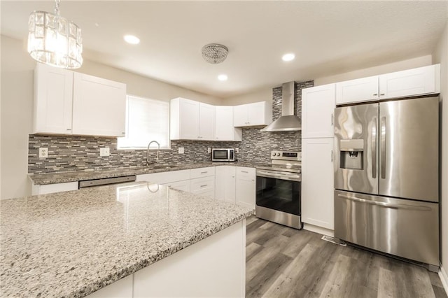 kitchen featuring white cabinetry, appliances with stainless steel finishes, dark hardwood / wood-style flooring, light stone countertops, and wall chimney exhaust hood