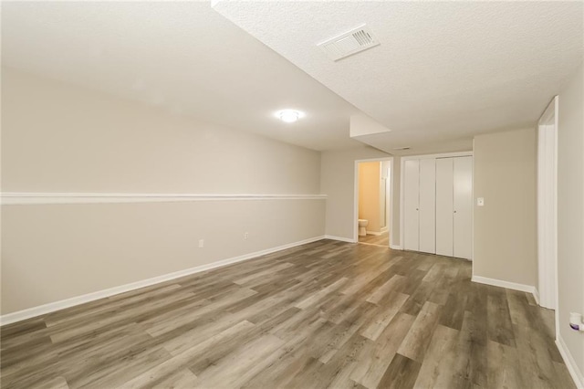 basement with dark hardwood / wood-style floors and a textured ceiling