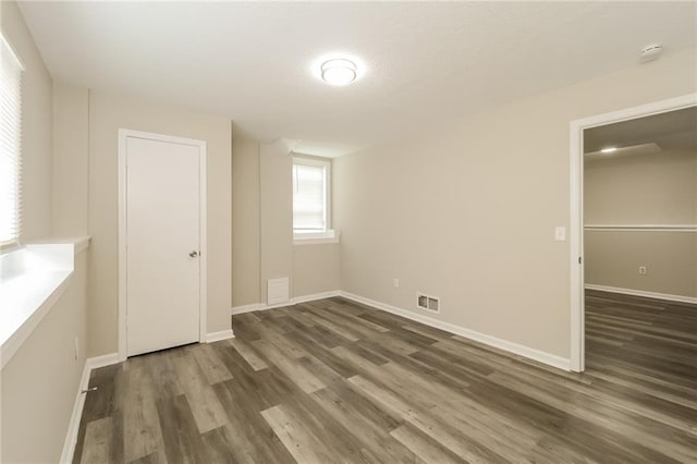 unfurnished room featuring dark wood-type flooring