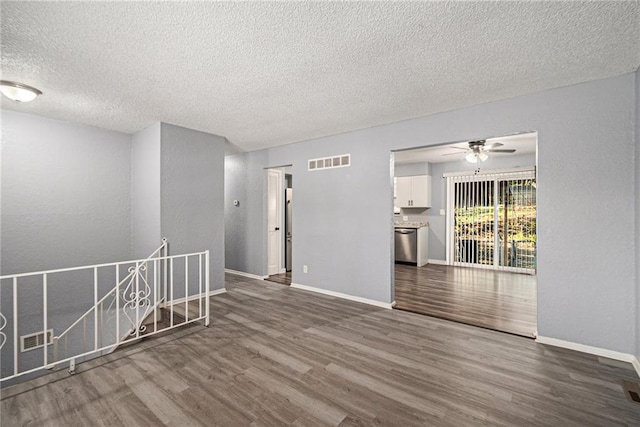 spare room featuring hardwood / wood-style flooring, ceiling fan, and a textured ceiling