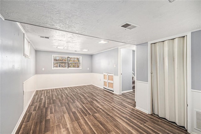 basement with dark hardwood / wood-style flooring and a textured ceiling