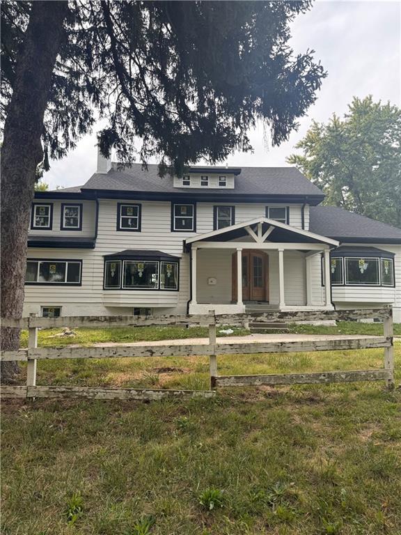 4203 E 68th St, Kansas City, MO 64132 - view of front of house with a chimney and a porch