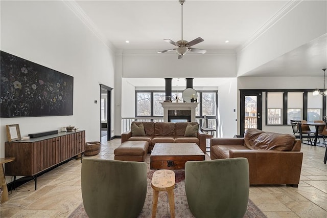 living area with ornamental molding, a fireplace, stone tile flooring, and baseboards