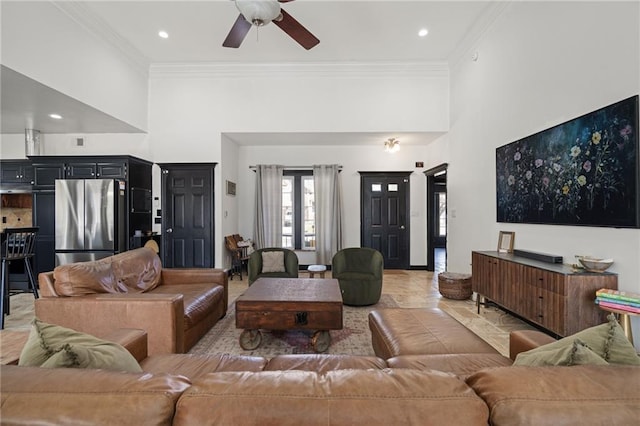 living area with ceiling fan, a high ceiling, ornamental molding, and recessed lighting