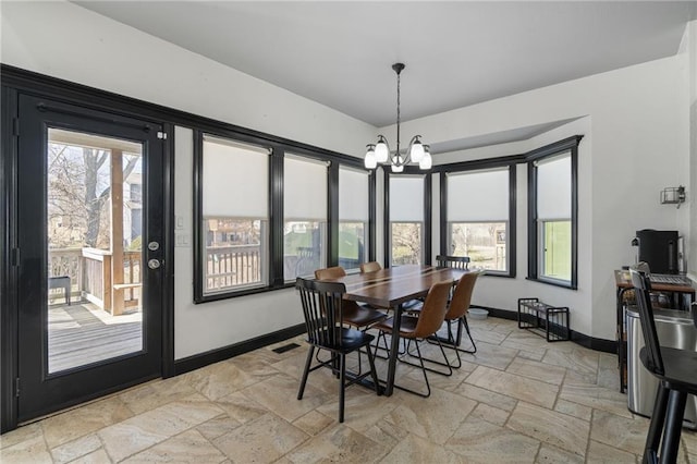 dining room featuring visible vents, an inviting chandelier, stone tile flooring, and baseboards