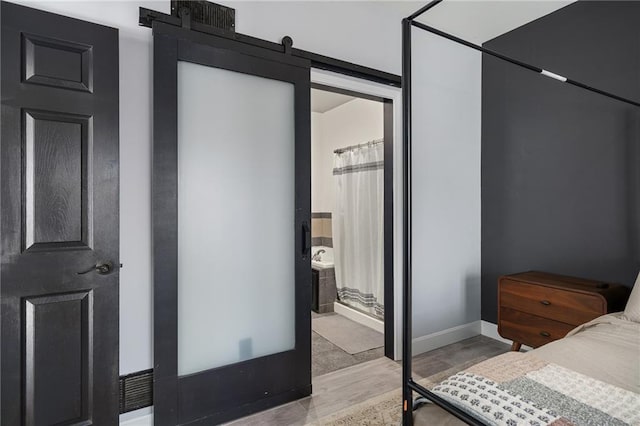 bedroom with baseboards and a barn door