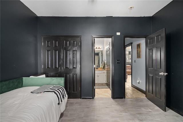 bedroom with baseboards and ensuite bath