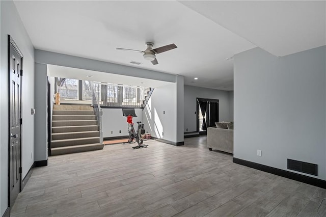 workout area featuring a ceiling fan, baseboards, visible vents, and wood finished floors