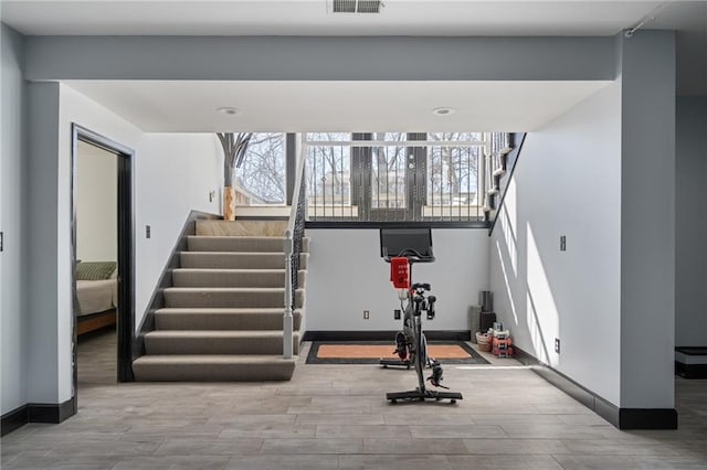 workout room featuring visible vents, baseboards, and wood finished floors