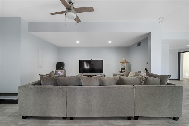 living room featuring visible vents, light wood-type flooring, a ceiling fan, and recessed lighting