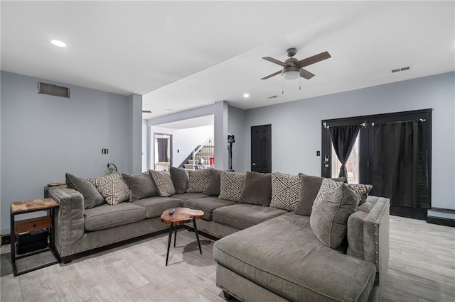 living area with recessed lighting, visible vents, light wood-style flooring, stairway, and ceiling fan