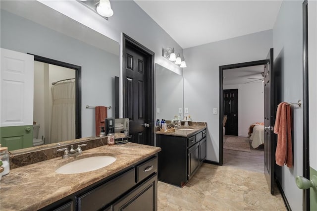 full bathroom with ceiling fan, connected bathroom, two vanities, and a sink