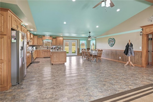 kitchen with vaulted ceiling, ceiling fan, a kitchen island, and appliances with stainless steel finishes