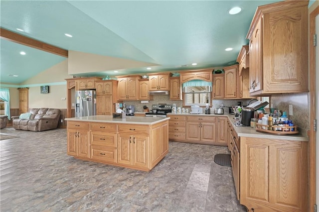 kitchen featuring lofted ceiling with beams, tasteful backsplash, appliances with stainless steel finishes, and a kitchen island with sink