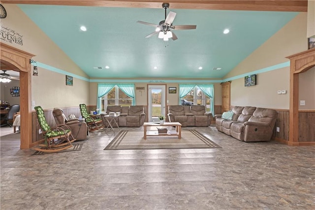 living room featuring high vaulted ceiling, wooden walls, and ceiling fan