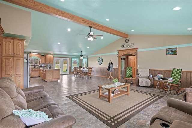 living room with wood walls, vaulted ceiling with beams, and ceiling fan