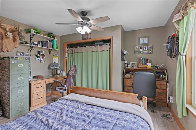 bedroom with hardwood / wood-style floors, ceiling fan, and a closet