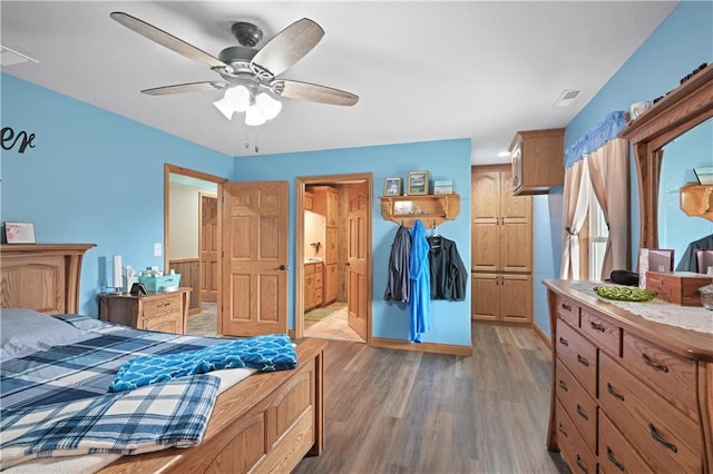 bedroom featuring hardwood / wood-style flooring, ceiling fan, and ensuite bath