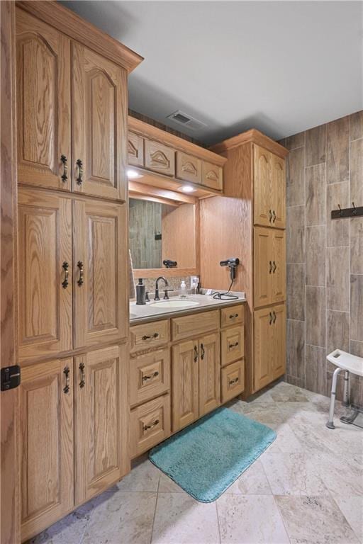 bathroom featuring vanity and tile walls