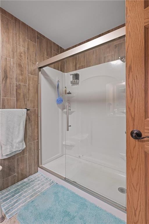 bathroom featuring tile walls, an enclosed shower, and tile patterned flooring