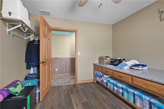 bedroom featuring wood walls, dark hardwood / wood-style floors, and ceiling fan