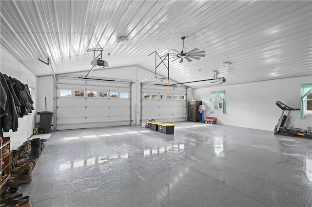 garage featuring water heater, ceiling fan, and a garage door opener