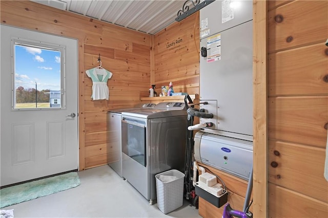 laundry area with wooden walls and washer and dryer